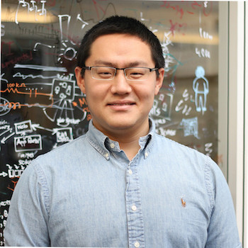 Man in blue shirt standing in front of white board