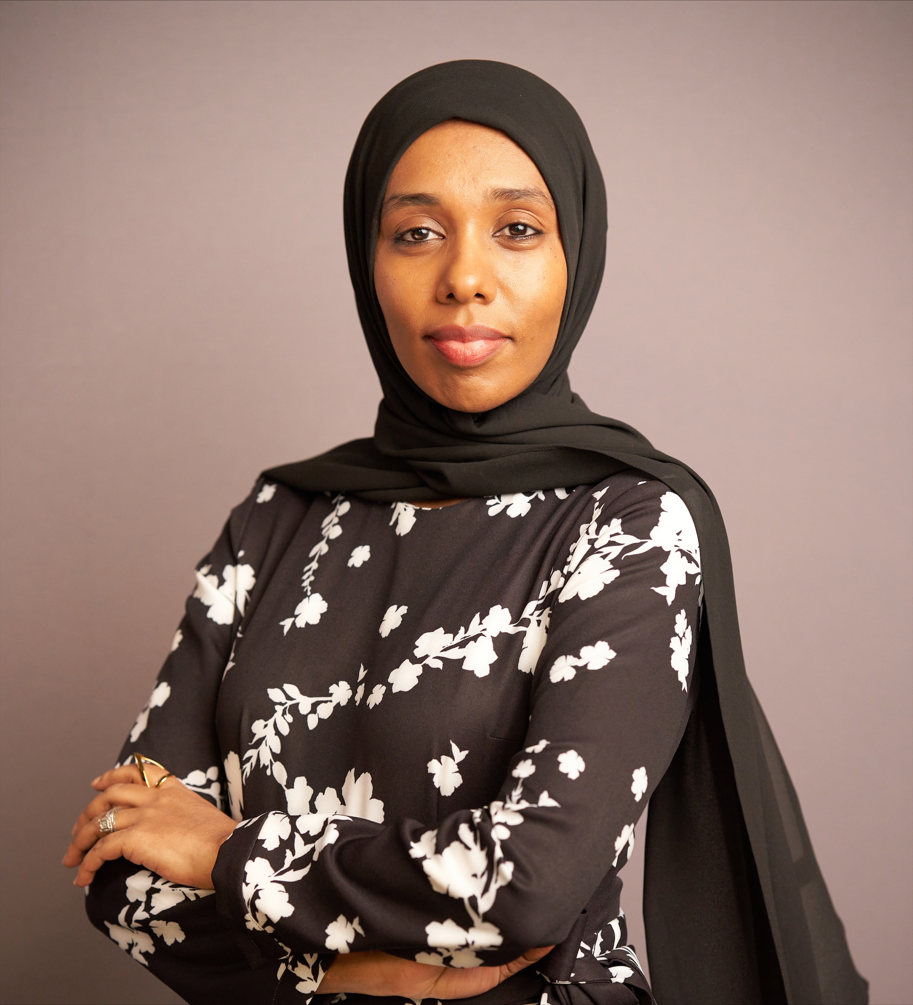 Woman in hijab standing with arms folded in front of her