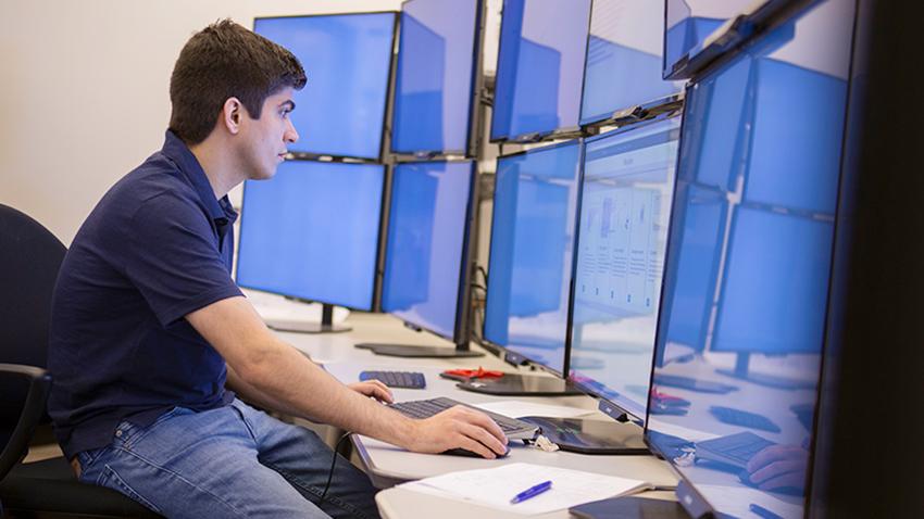 man at computer with multiple monitors