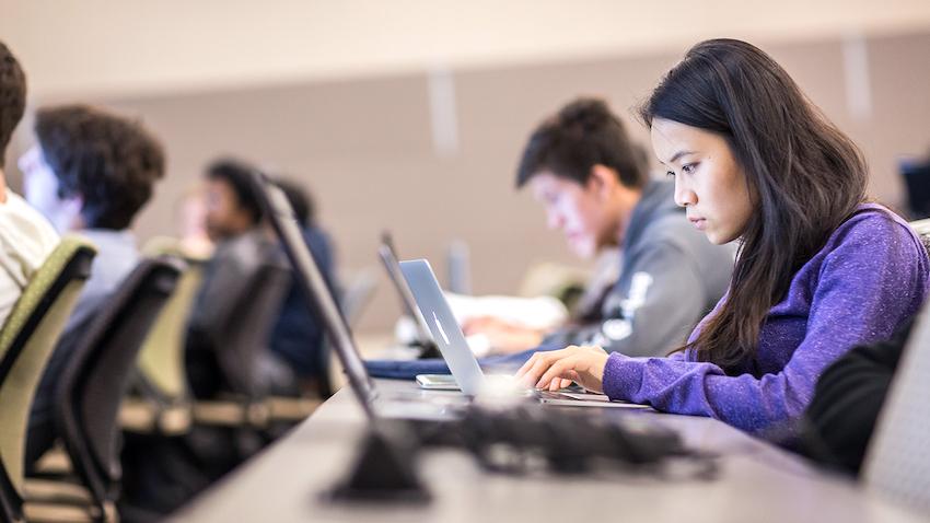 female student in computer science class working at her laptop